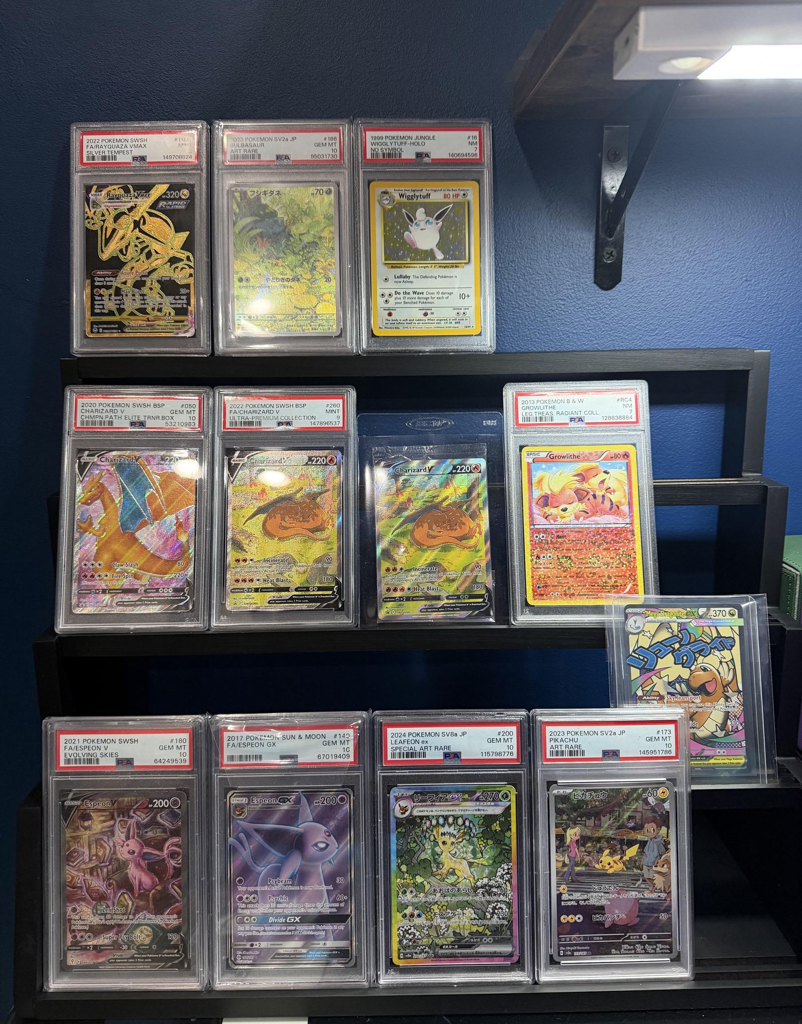 A curated display shelf of graded and high-value trading cards from Rarewake's inventory